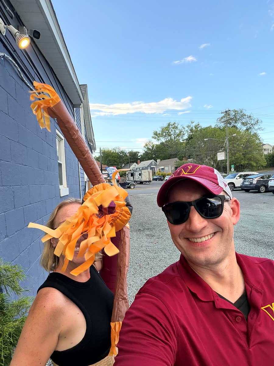Ben and Nicole outside the brewery next to an orange wacky waving inflatable arm tube man in the parking lot.